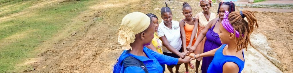Group of women holding hands together.